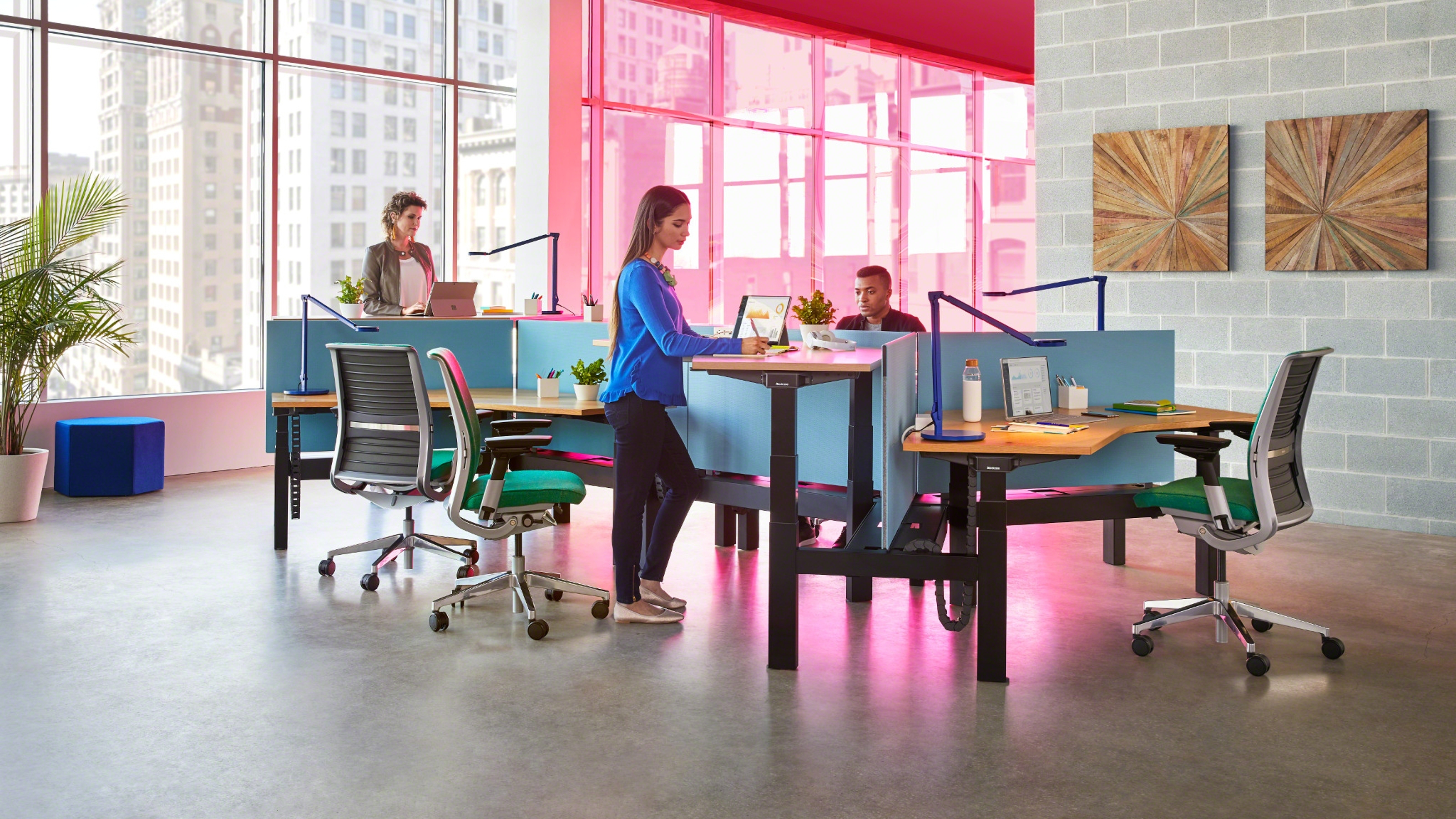 Pink lighted desking area with people talking to each other