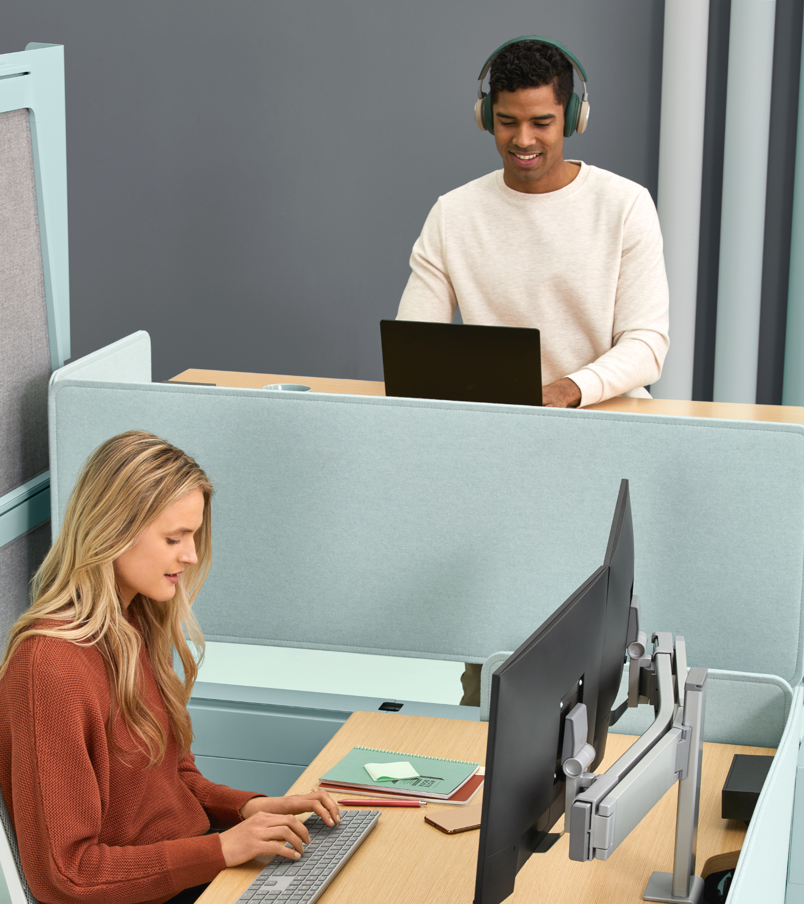 Man at a standing Bivi desk and woman at a sitting Bivi desk
